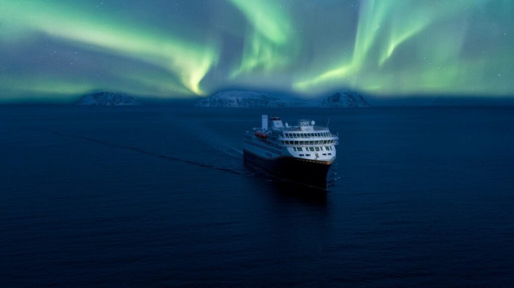 Northern Lights above Hurtigruten ship in Norway fjords