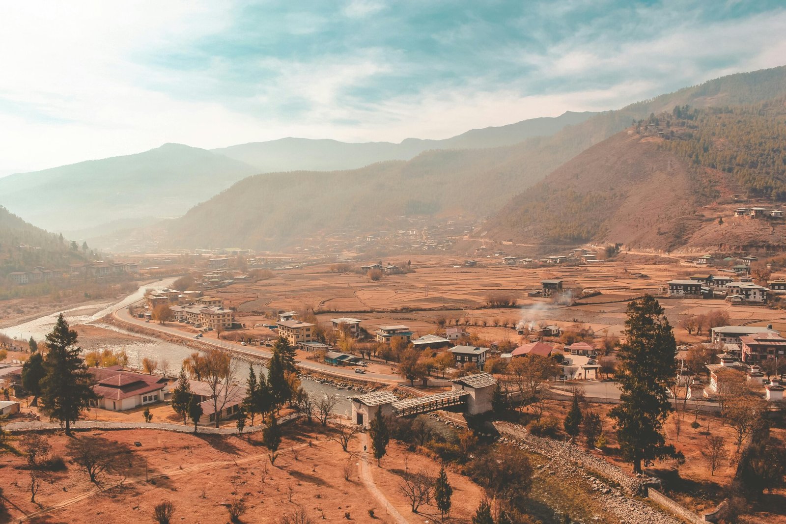 Serene Gangtey Valley in Bhutan covered in soft morning mist with rolling hills and monasteries — a peaceful, soulful destination ideal for luxury wellness travel and seeker-vibe journeys focused on stillness and reflection