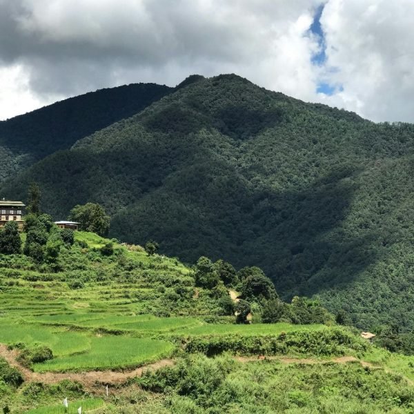 Bhutan unique travel experiences – Bumthang Valley sunrise over misty hills.